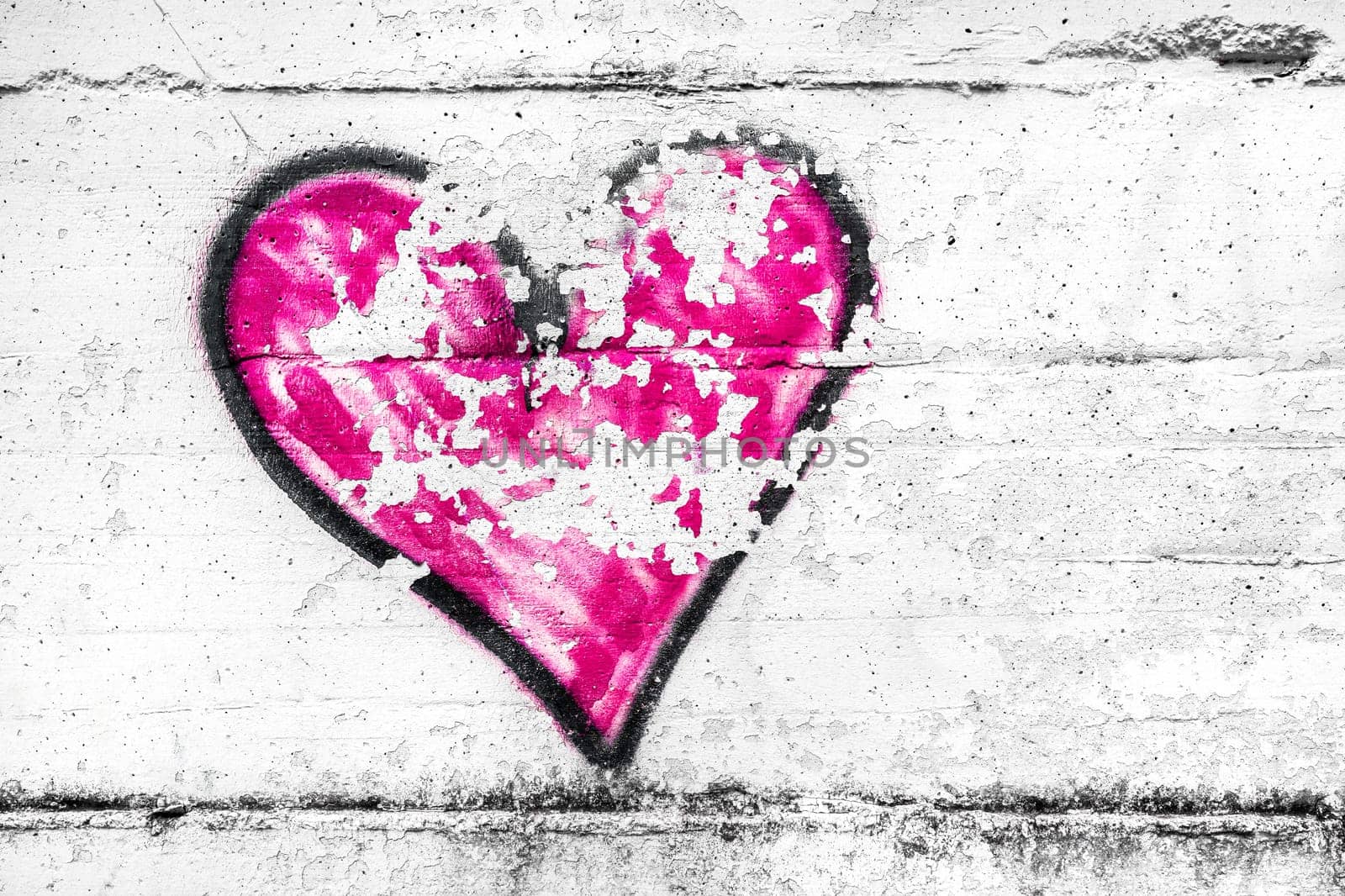 Painted pink abstract heart shape love symbol, dirty wall background, metaphor to urban and romantic valentine, grunge style.