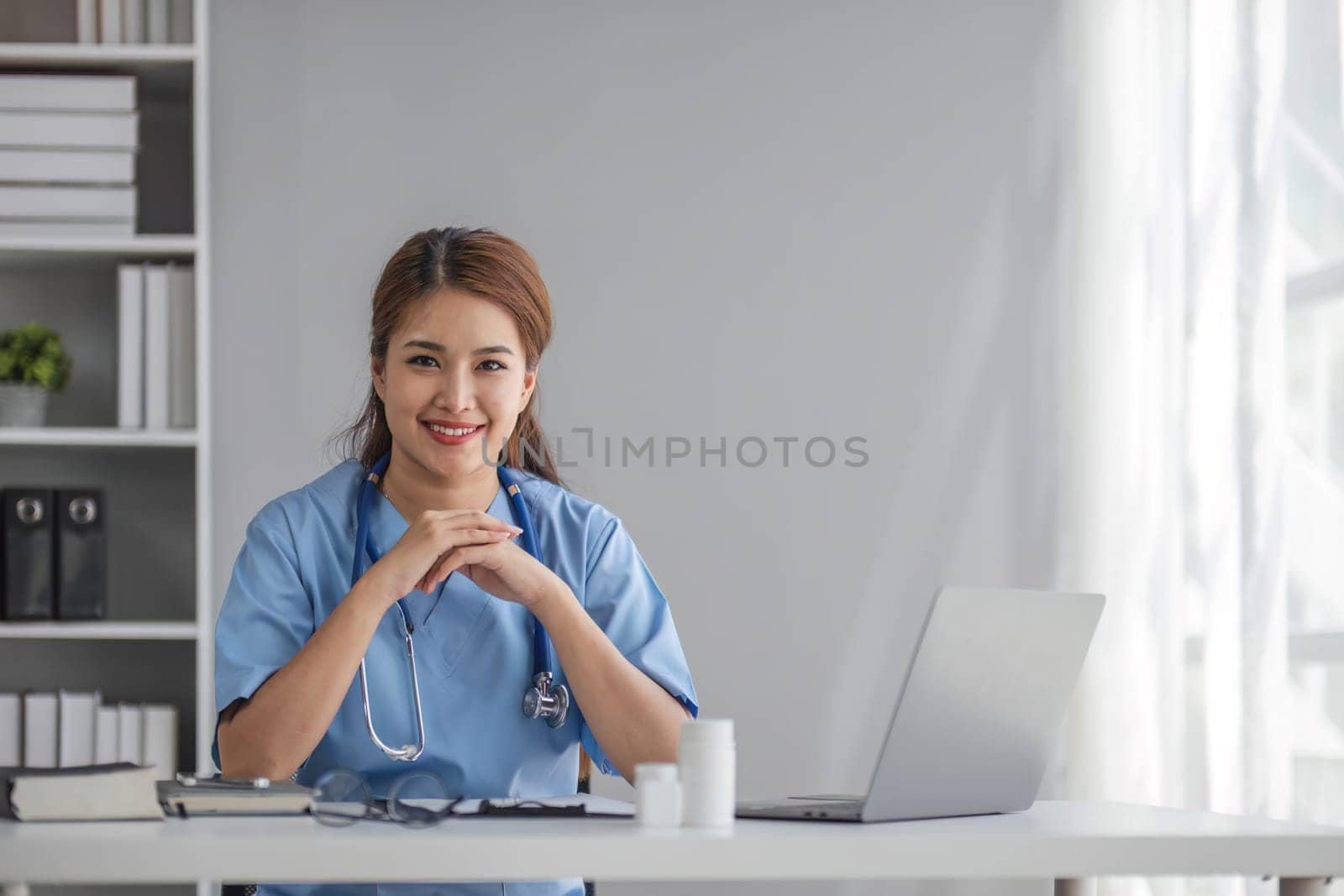 Portrait of female asian doctor standing in her office at clinic...