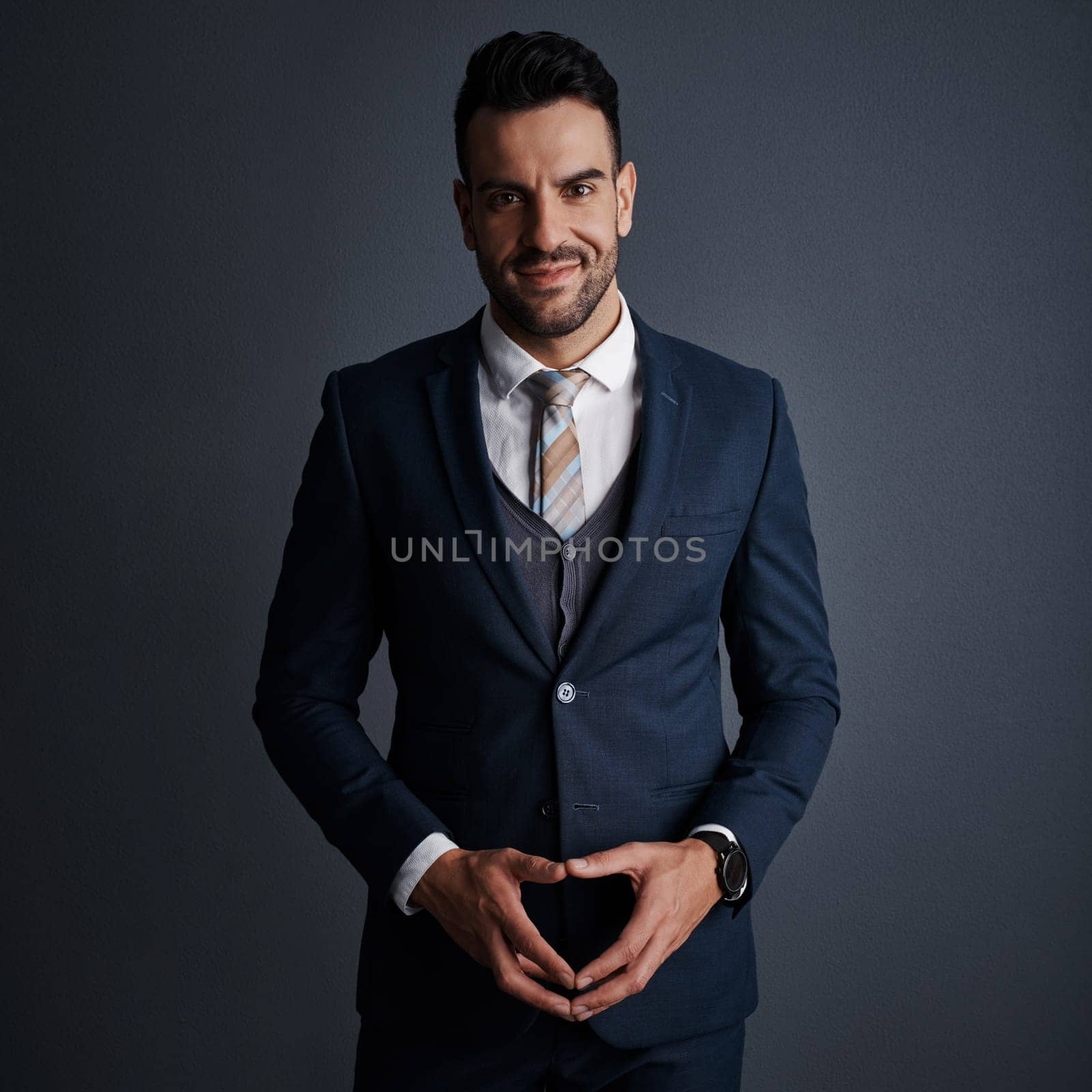 In business, focus is everything. Studio shot of a stylish and confident young businessman posing against a gray background. by YuriArcurs