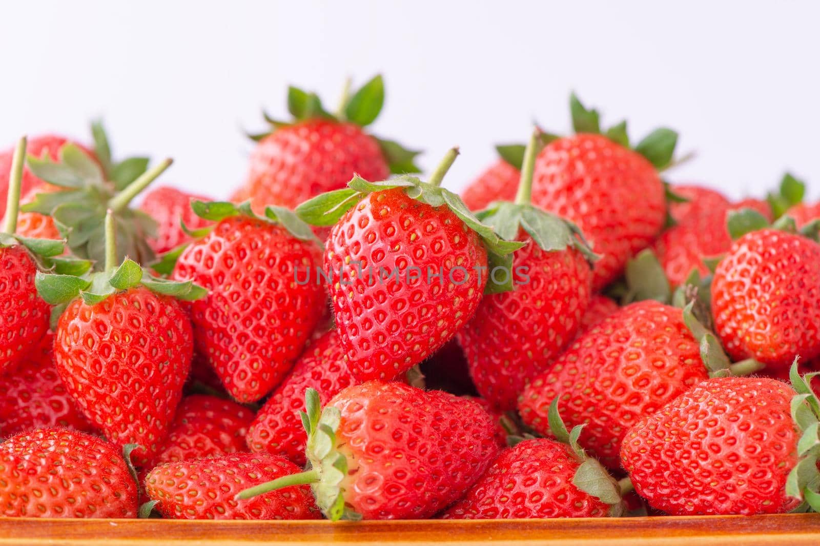 Beautiful and delicious strawberries in a wooden box basket, concept of organic farming, fresh direct delivery from orchard, close up.
