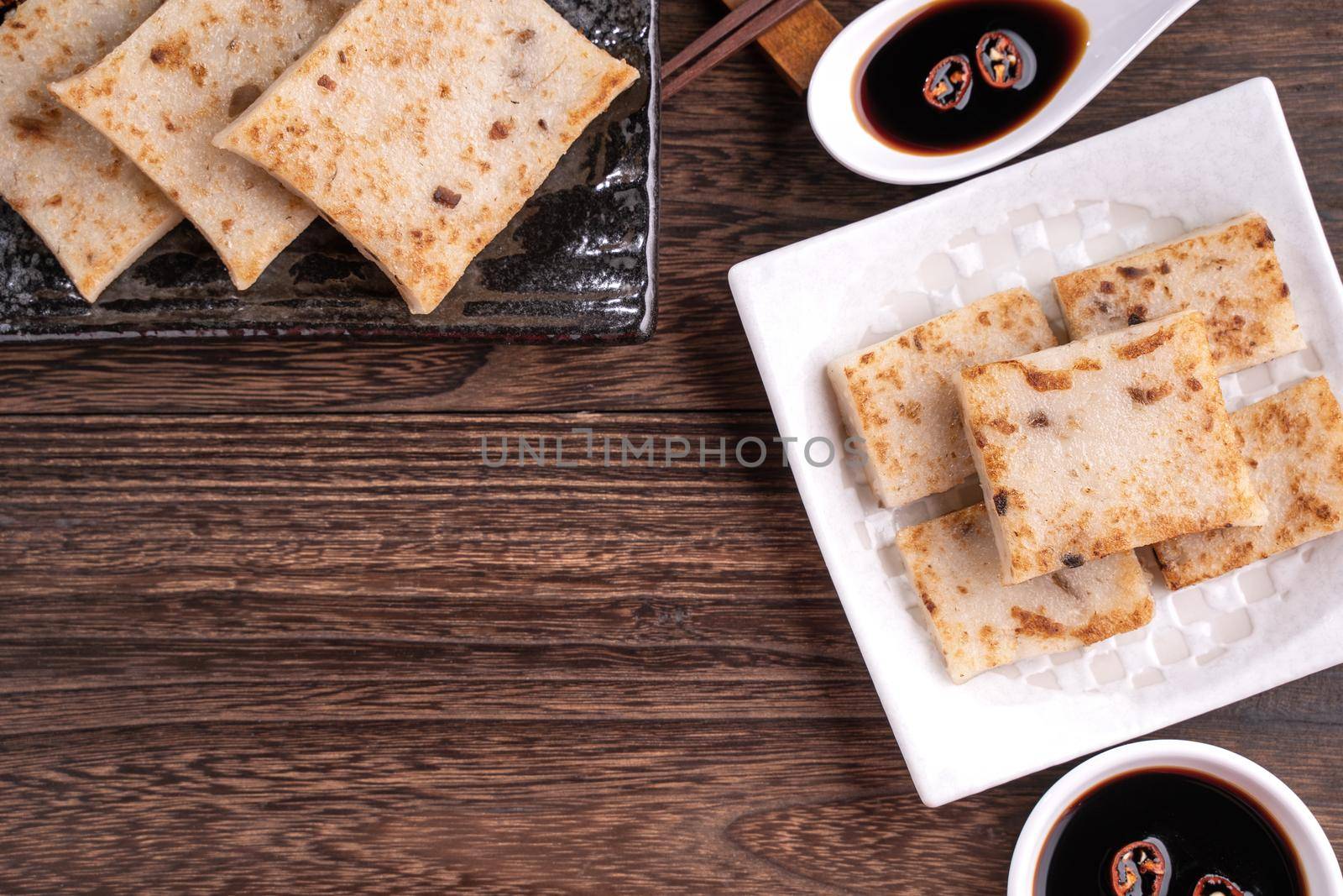 Delicious turnip cake, Chinese traditional radish cake in restaurant with soy sauce for new year's dishes, close up, copy space, top view, flat lay.