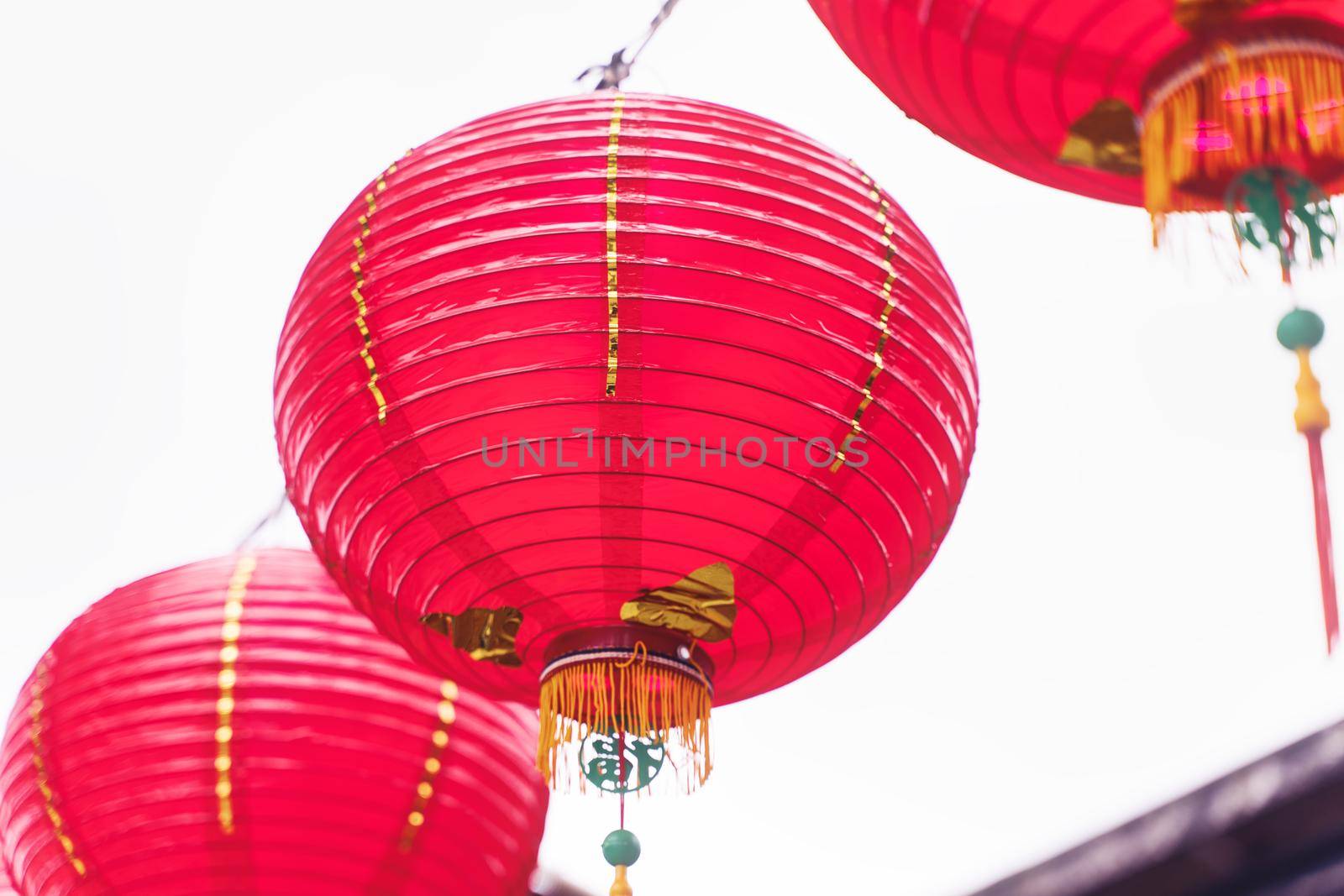 Beautiful round red lantern hanging on old traditional street, concept of Chinese lunar new year festival, close up. The undering word means blessing.