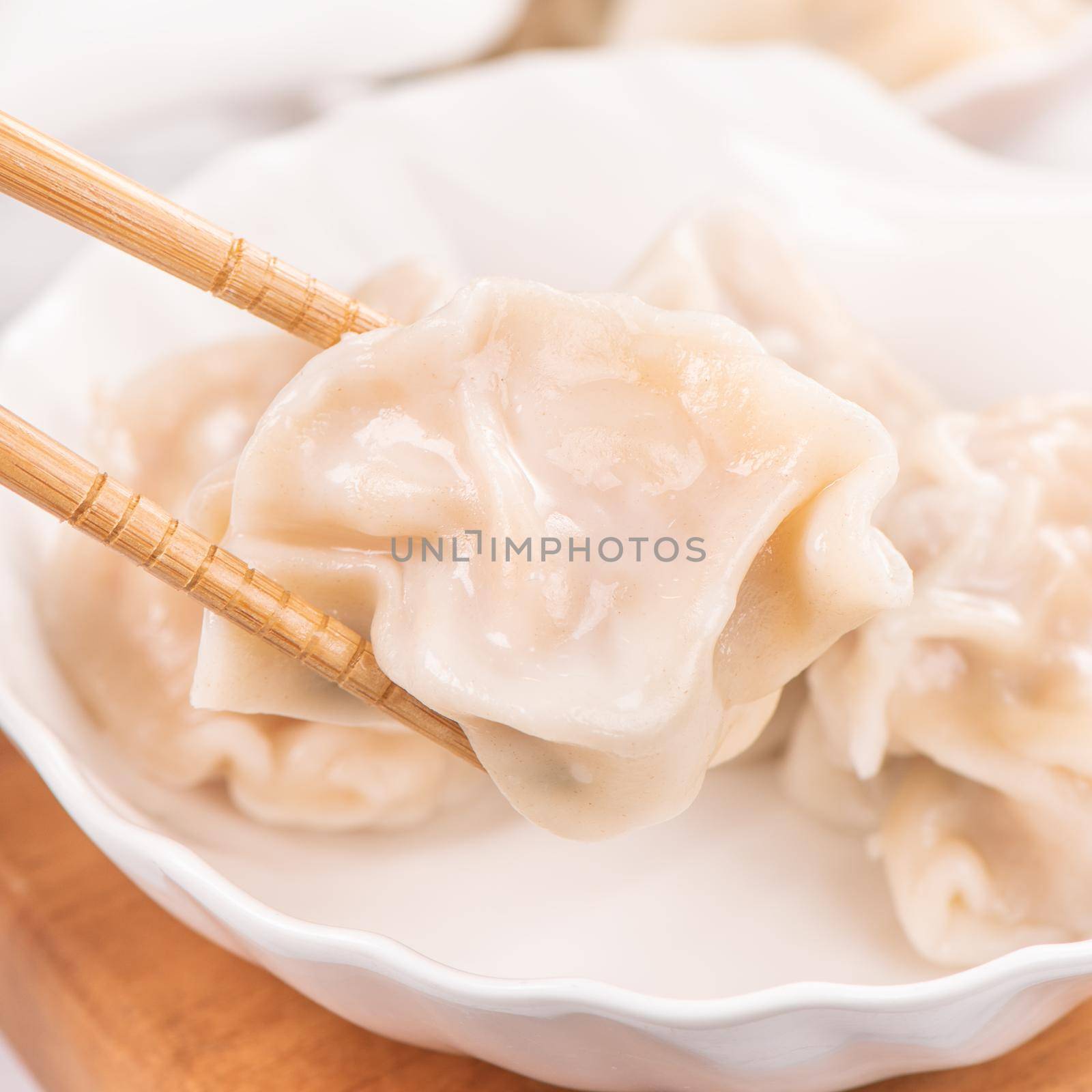 Fresh, delicious boiled pork, shrimp gyoza dumplings on white background with soy sauce and chopsticks, close up, lifestyle. Homemade design concept.