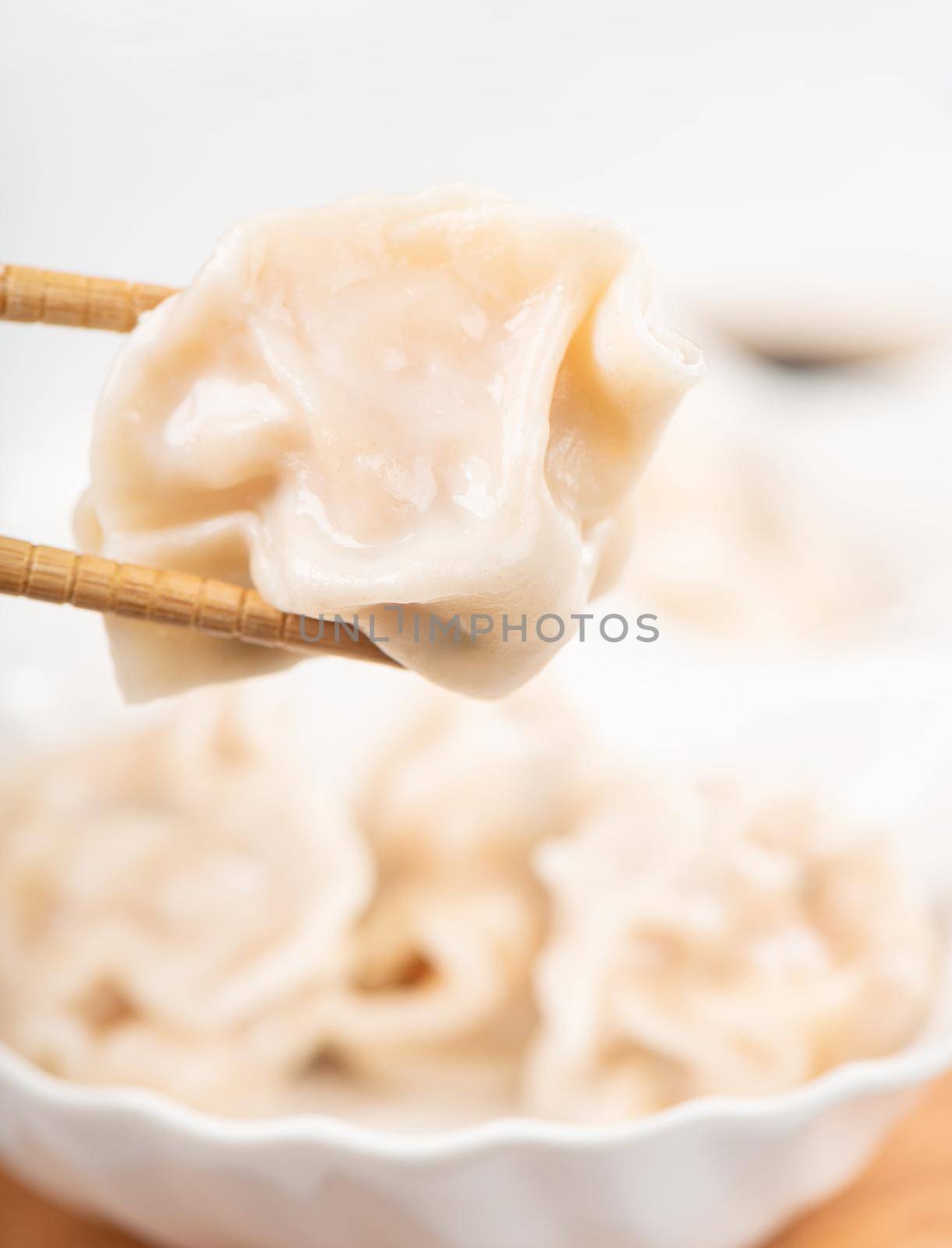 Fresh, delicious boiled pork, shrimp gyoza dumplings on white background with soy sauce and chopsticks, close up, lifestyle. Homemade design concept.