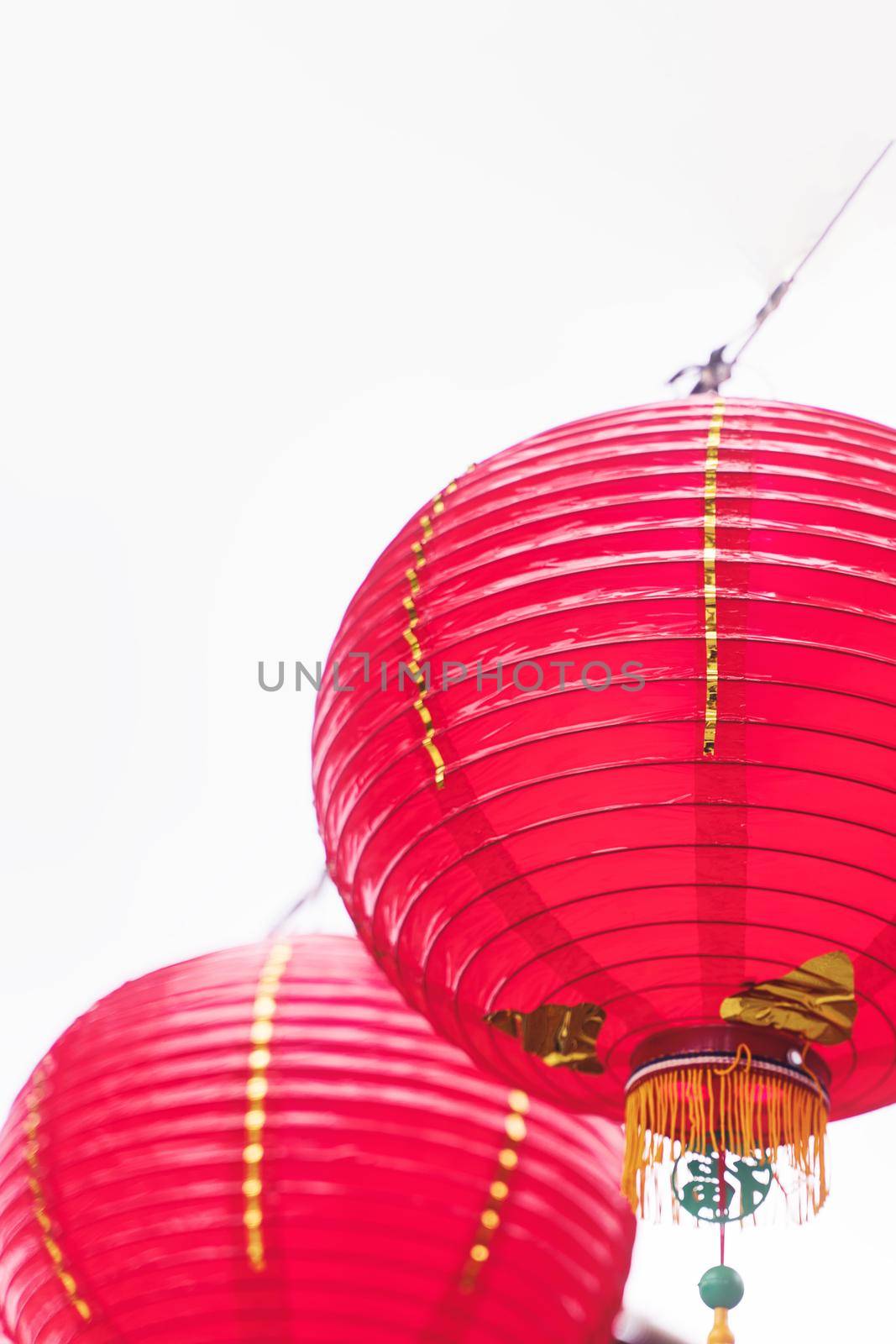 Beautiful round red lantern hanging on old traditional street, concept of Chinese lunar new year festival, close up. The undering word means blessing. by ROMIXIMAGE