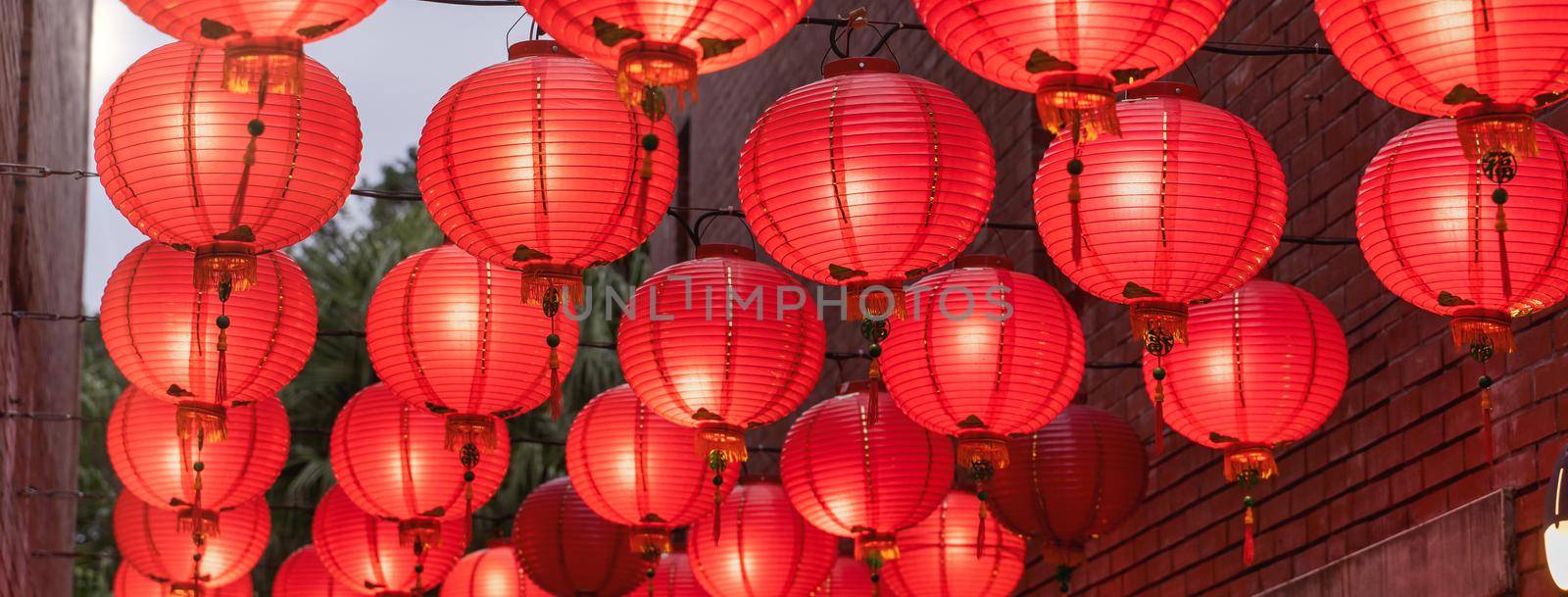 Beautiful round red lantern hanging on old traditional street, concept of Chinese lunar new year festival, close up. The undering word means blessing.