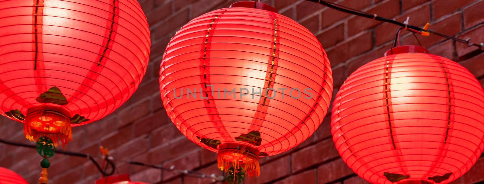 Beautiful round red lantern hanging on old traditional street, concept of Chinese lunar new year festival, close up. The undering word means blessing.