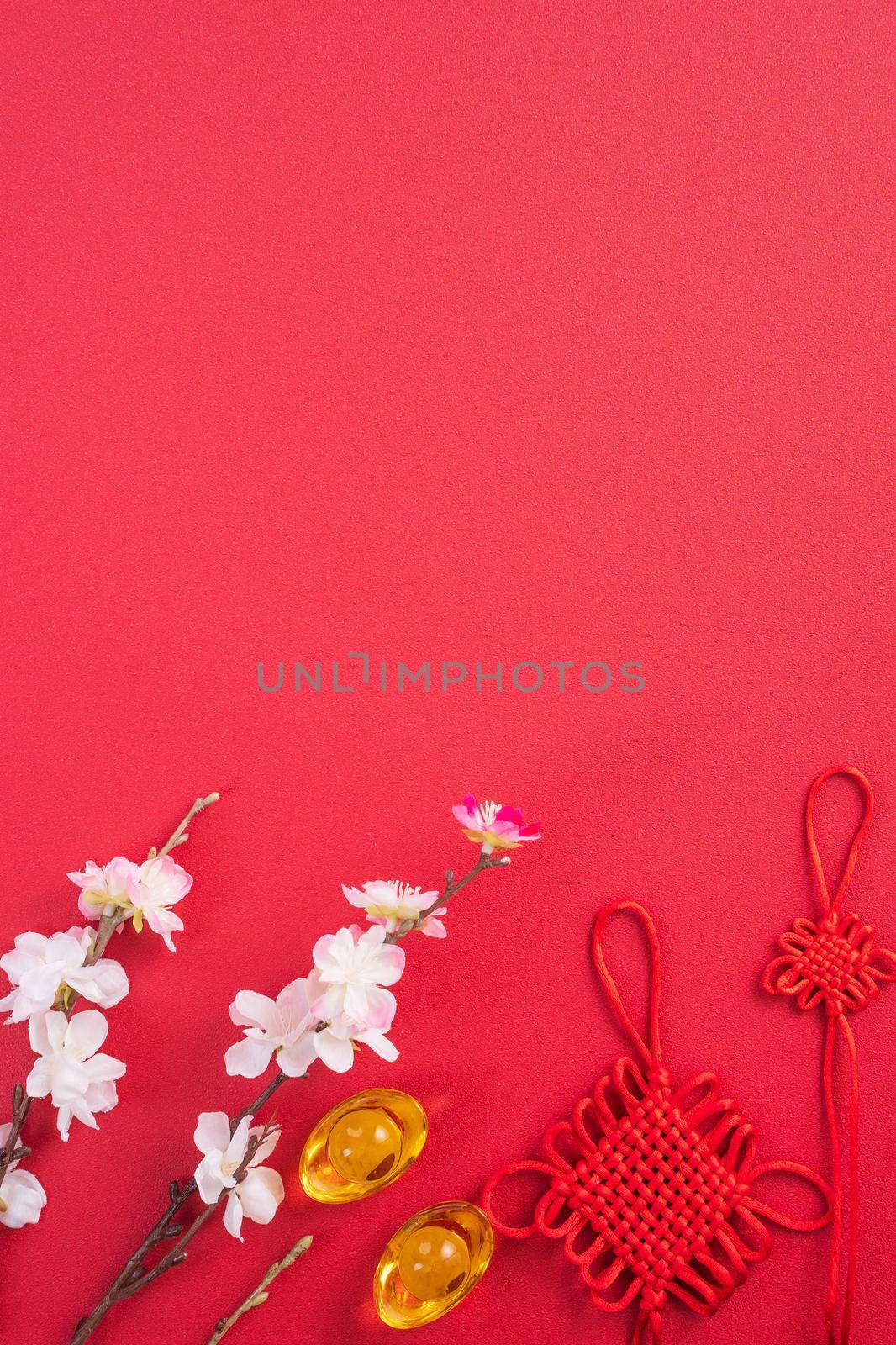 Design concept of Chinese lunar new year - Beautiful Chinese knot with plum blossom isolated on red background, flat lay, top view, overhead layout. by ROMIXIMAGE