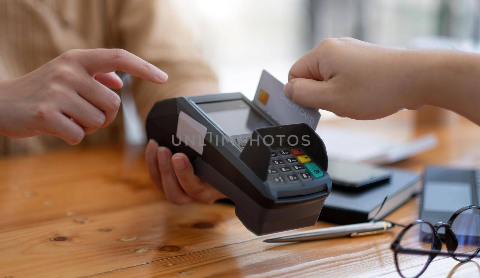 Close-up of asian customer using his credit card to swipe with EDC to pay, shopping with credit card concept.