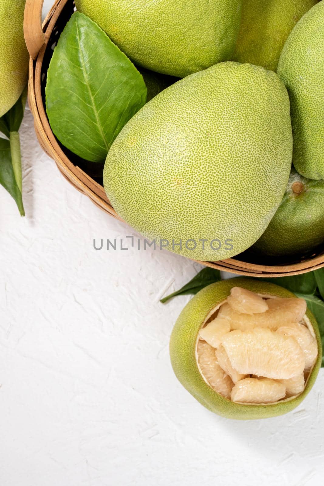 Fresh peeled pomelo, pummelo, grapefruit, shaddock on bright wooden background. Autumn seasonal fruit, top view, flat lay, tabletop shot.