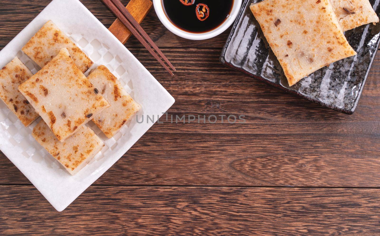 Delicious turnip cake, Chinese traditional radish cake in restaurant with soy sauce for new year's dishes, close up, copy space, top view, flat lay.