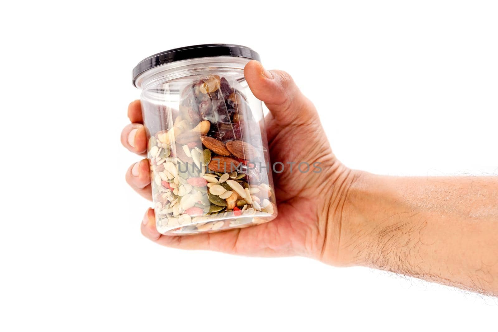 Human hand holding whole grains and dried fruit plastic bottle isolated on white background. by wattanaphob