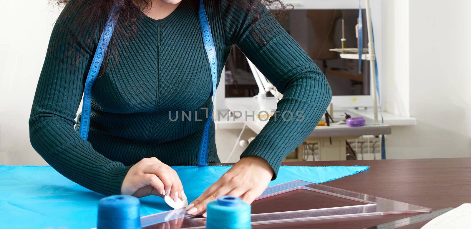 Seamstress at work with cloth fabric in tailor studio by Mariakray