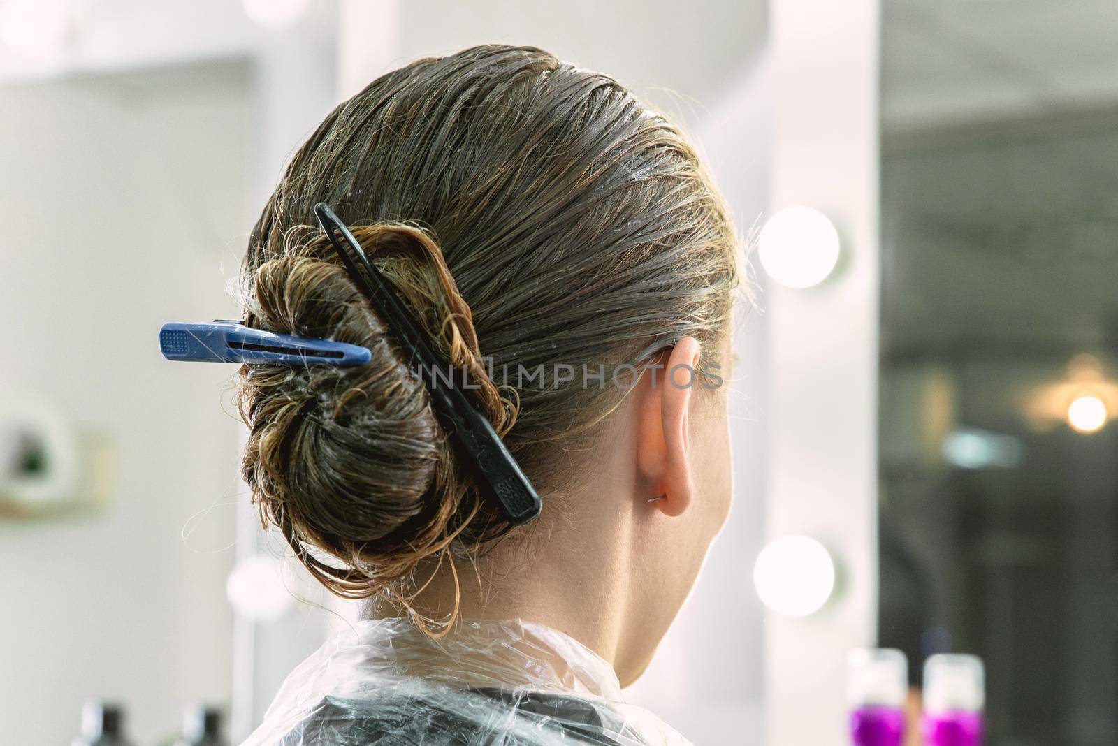 Young girl having hair treatment mask in a beauty salon, young girl during care process by Mariakray