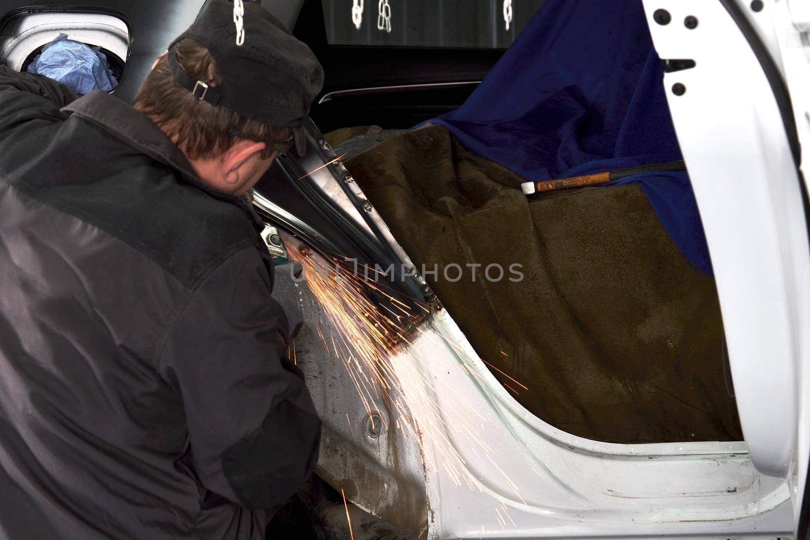 Cutting metal part with sparks in car service station