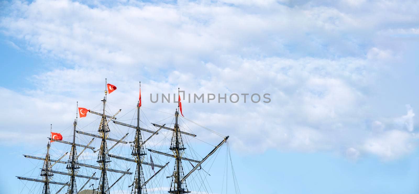 Masts of the ship with turkish flags on the background of the blue sky. The concept of travel and freedom. Copy space