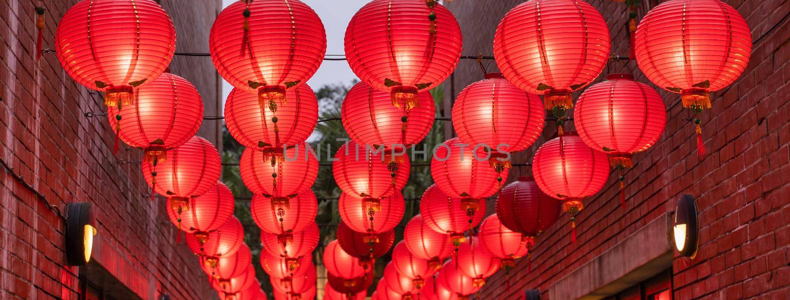 Beautiful round red lantern hanging on old traditional street, concept of Chinese lunar new year festival, close up. The undering word means blessing. by ROMIXIMAGE