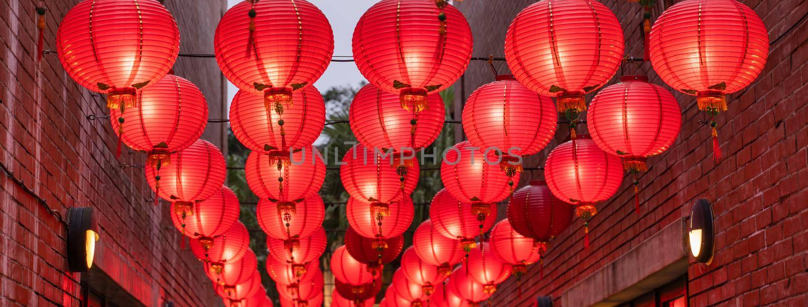 Beautiful round red lantern hanging on old traditional street, concept of Chinese lunar new year festival, close up. The undering word means blessing.