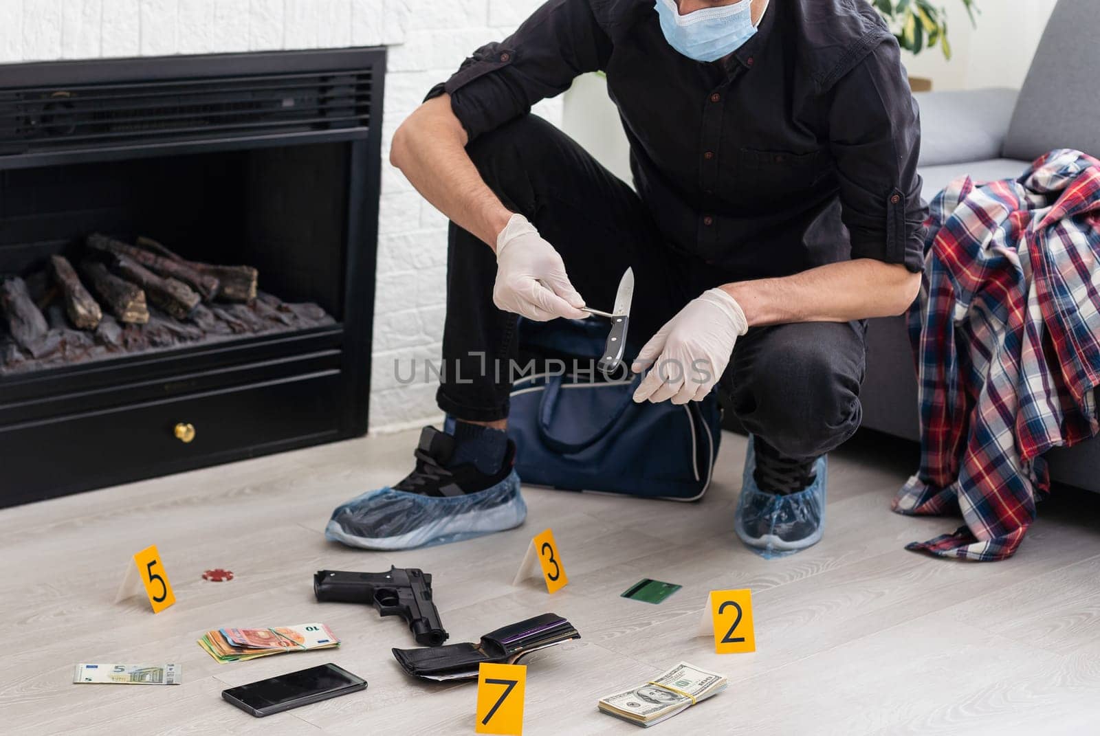 Criminological expert collecting evidence at the crime scene. High quality photo