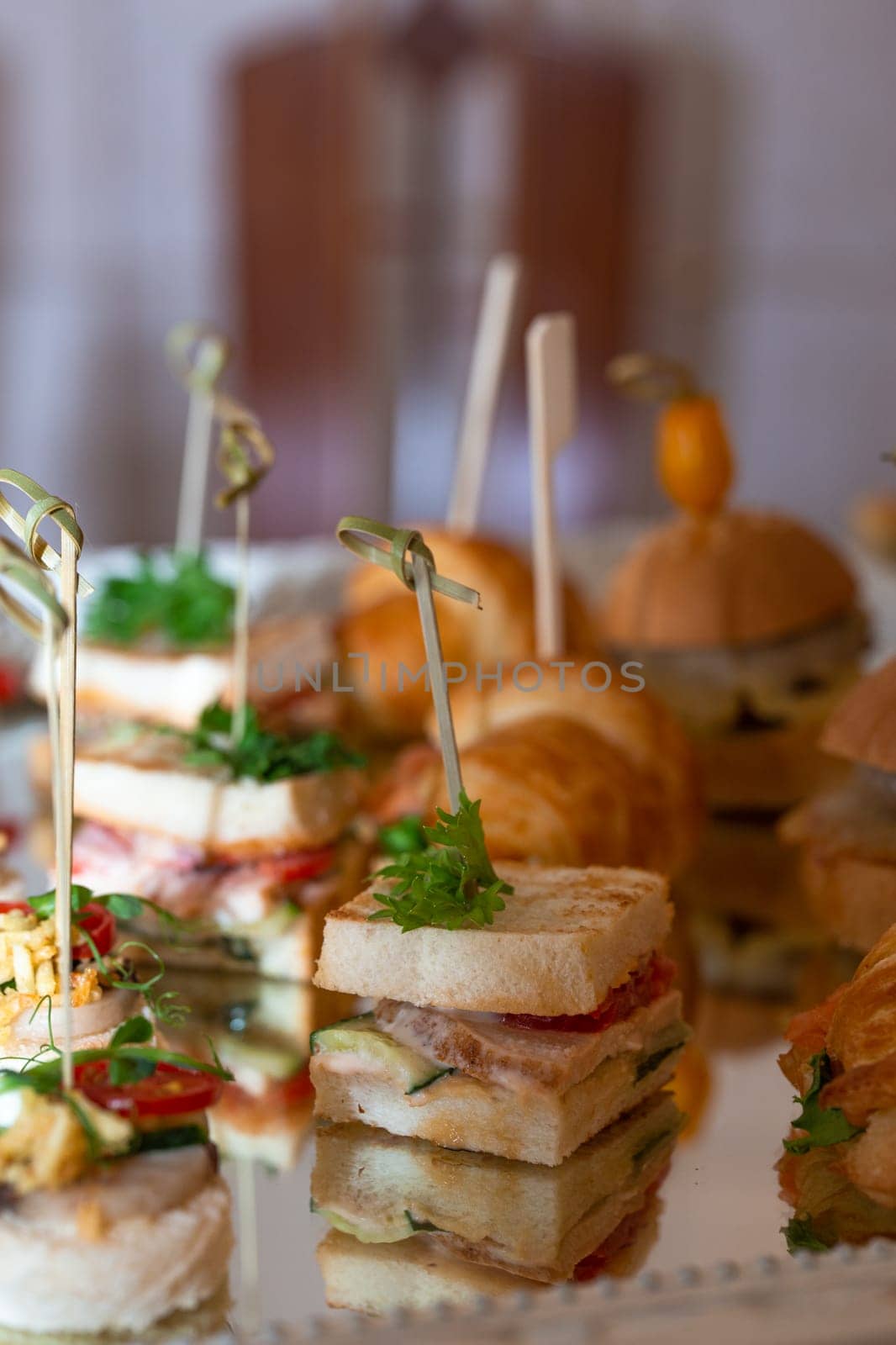 assorted canapes on a glass tray on a buffet table by Pukhovskiy