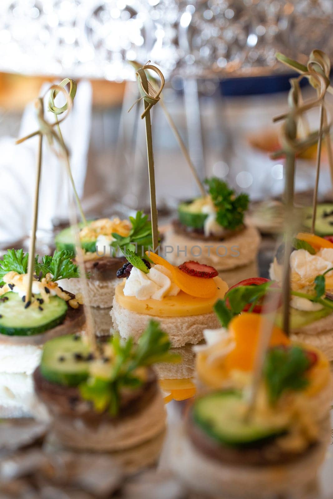 assorted canapes on a glass tray on a buffet table.