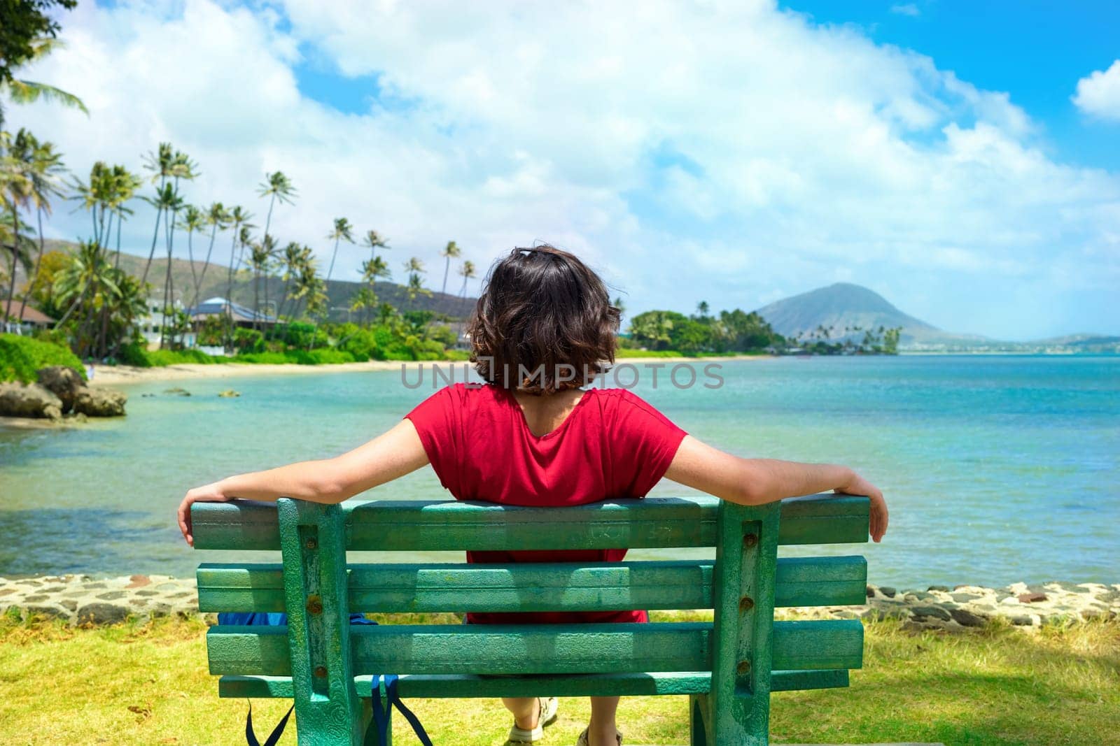 Young woman resting on park bench along Hawaiian ocean by jarenwicklund