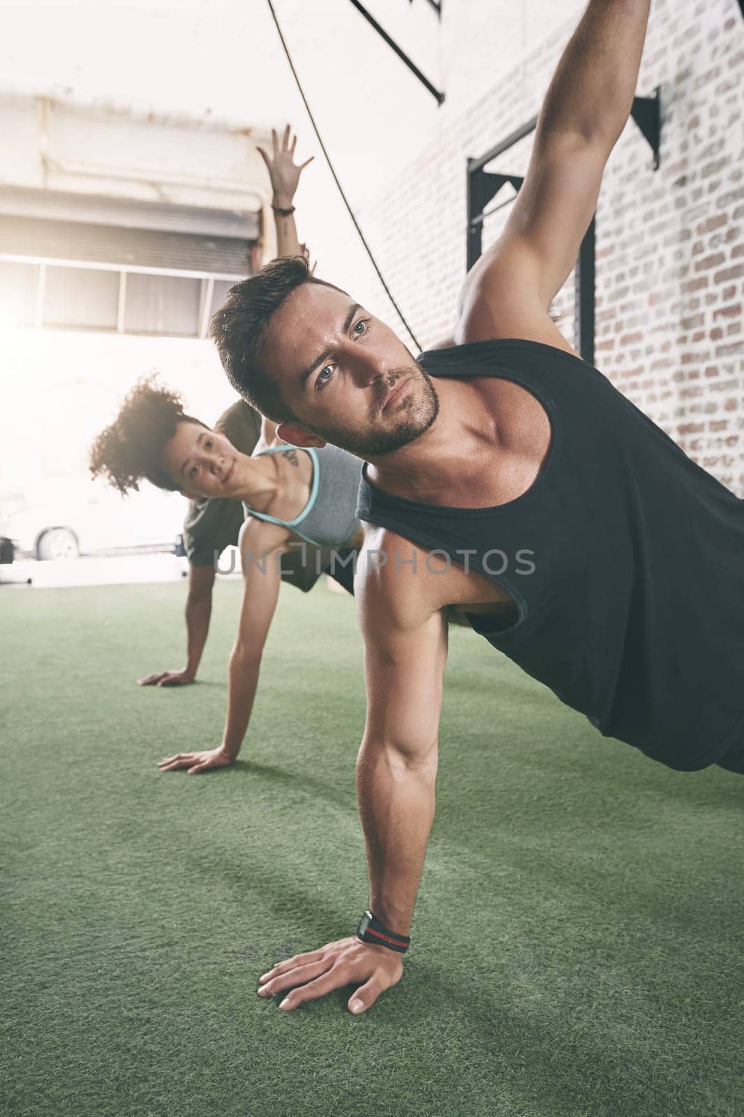 Try group fitness, the results speak for itself. a fitness group doing the side plank together at the gym. by YuriArcurs