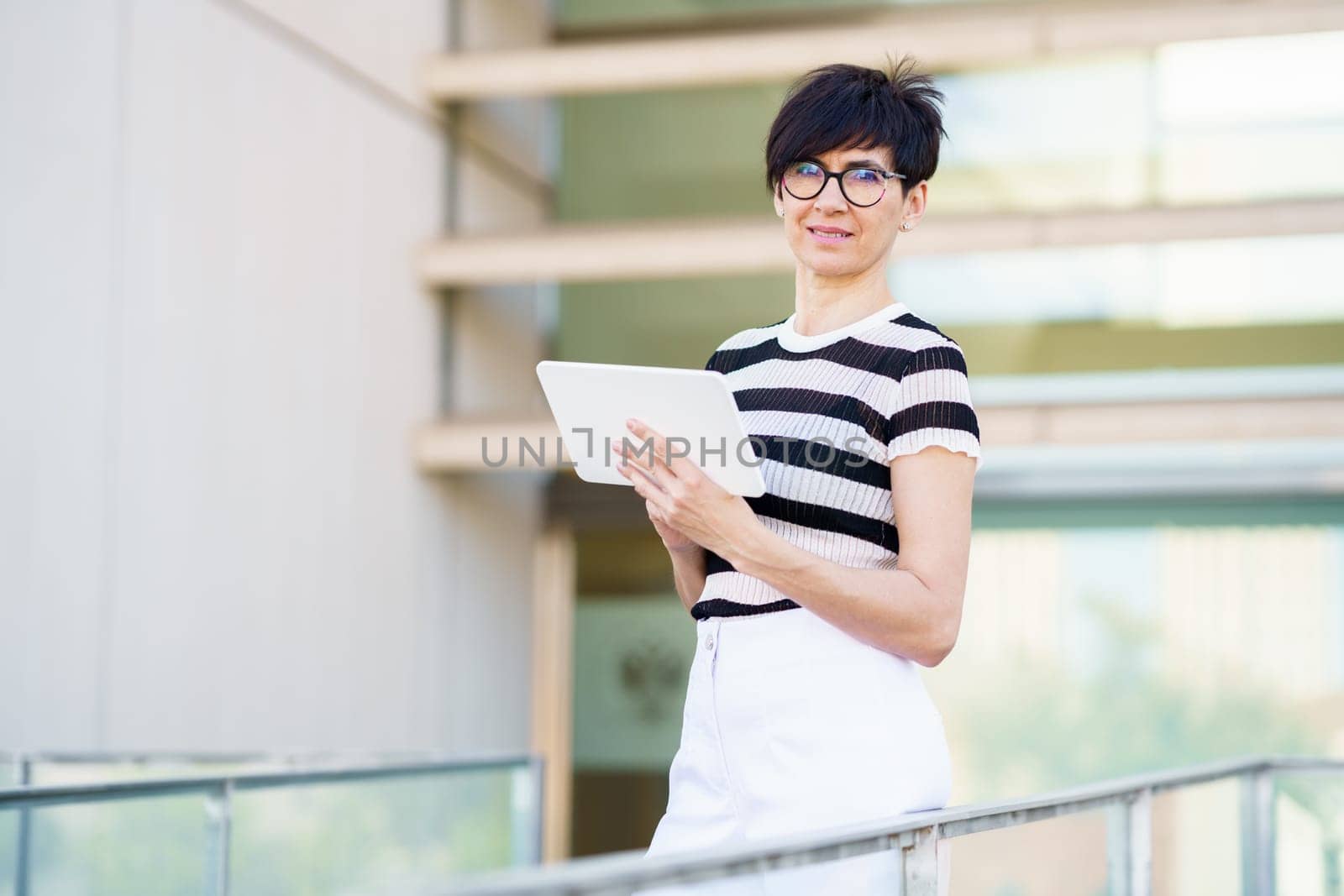 Thoughtful woman with tablet on balcony by javiindy