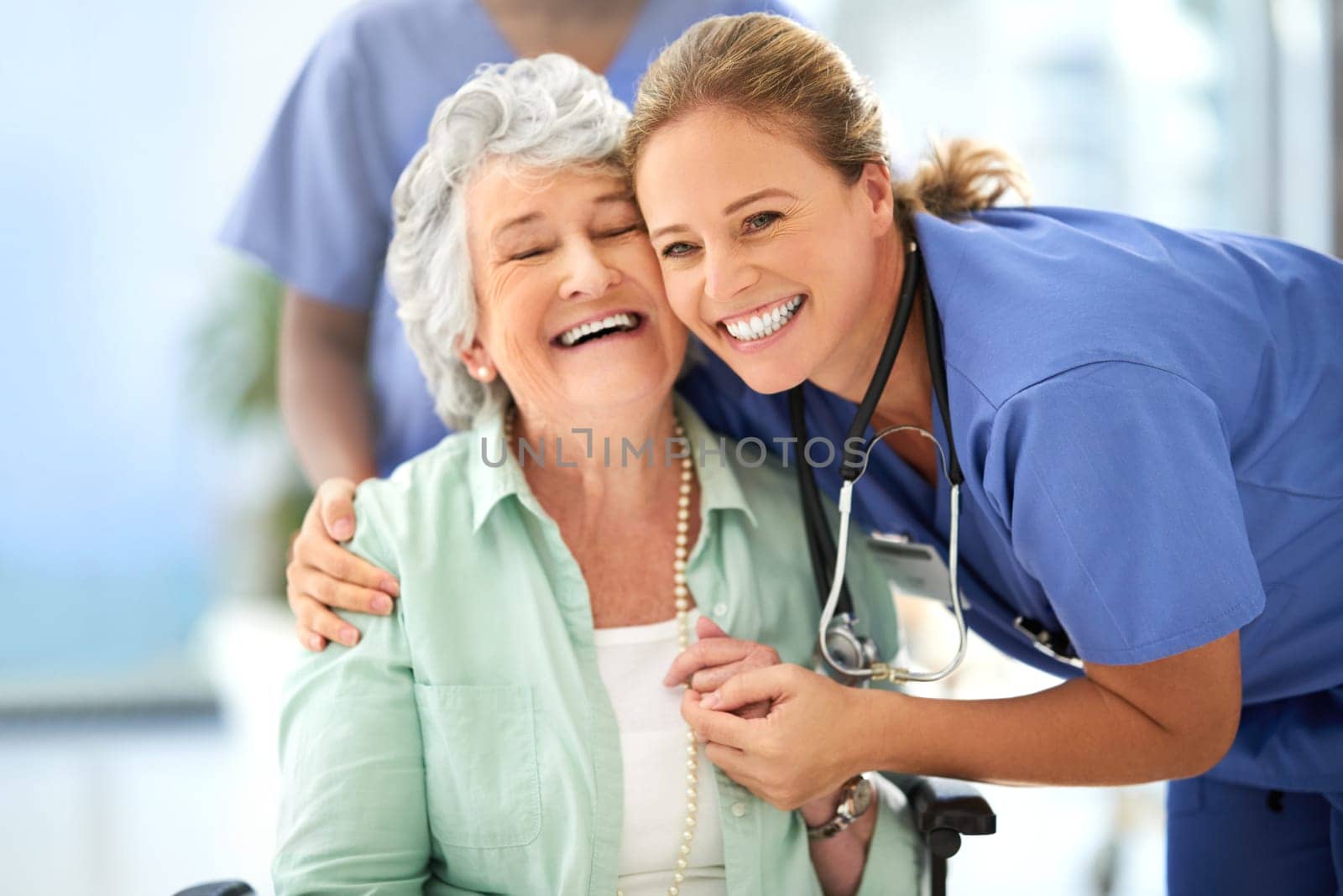 Nurse, senior woman and hug of caregiver and happy smile with support and care in hospital. Wheelchair, women and healthcare employee help with elderly female patient with love in a health clinic.