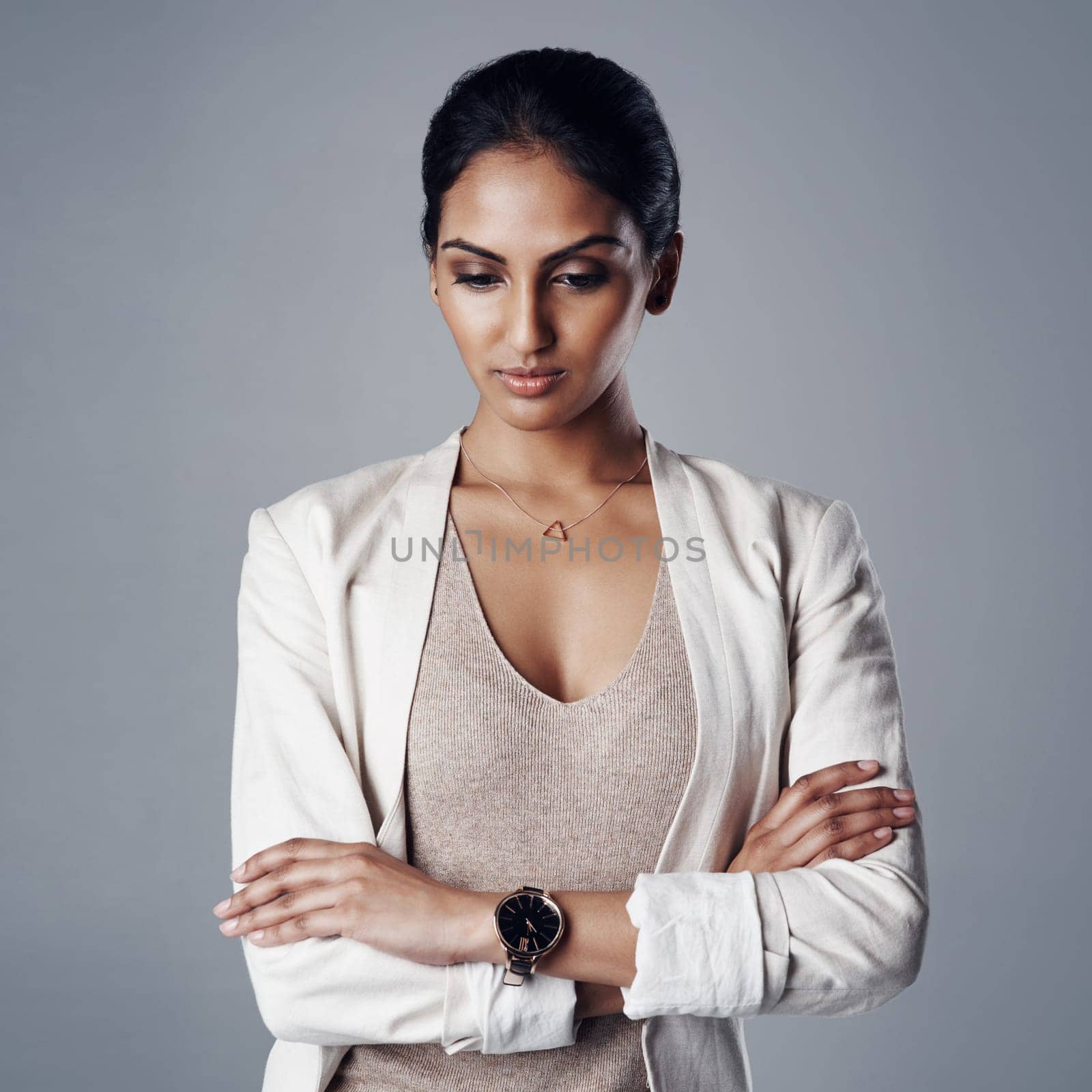 Always mindful of her next business move. Studio shot of a young businesswoman looking pensive against a gray background