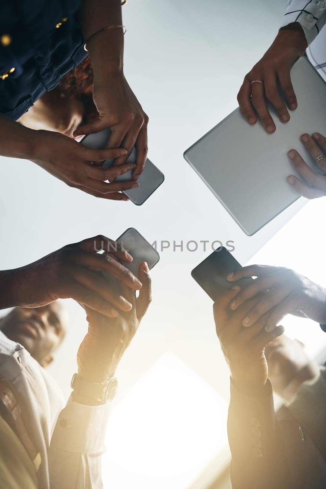 Wireless technology leads the way forward. Closeup shot of a group of businesspeople using digital devices in synchronicity in an office