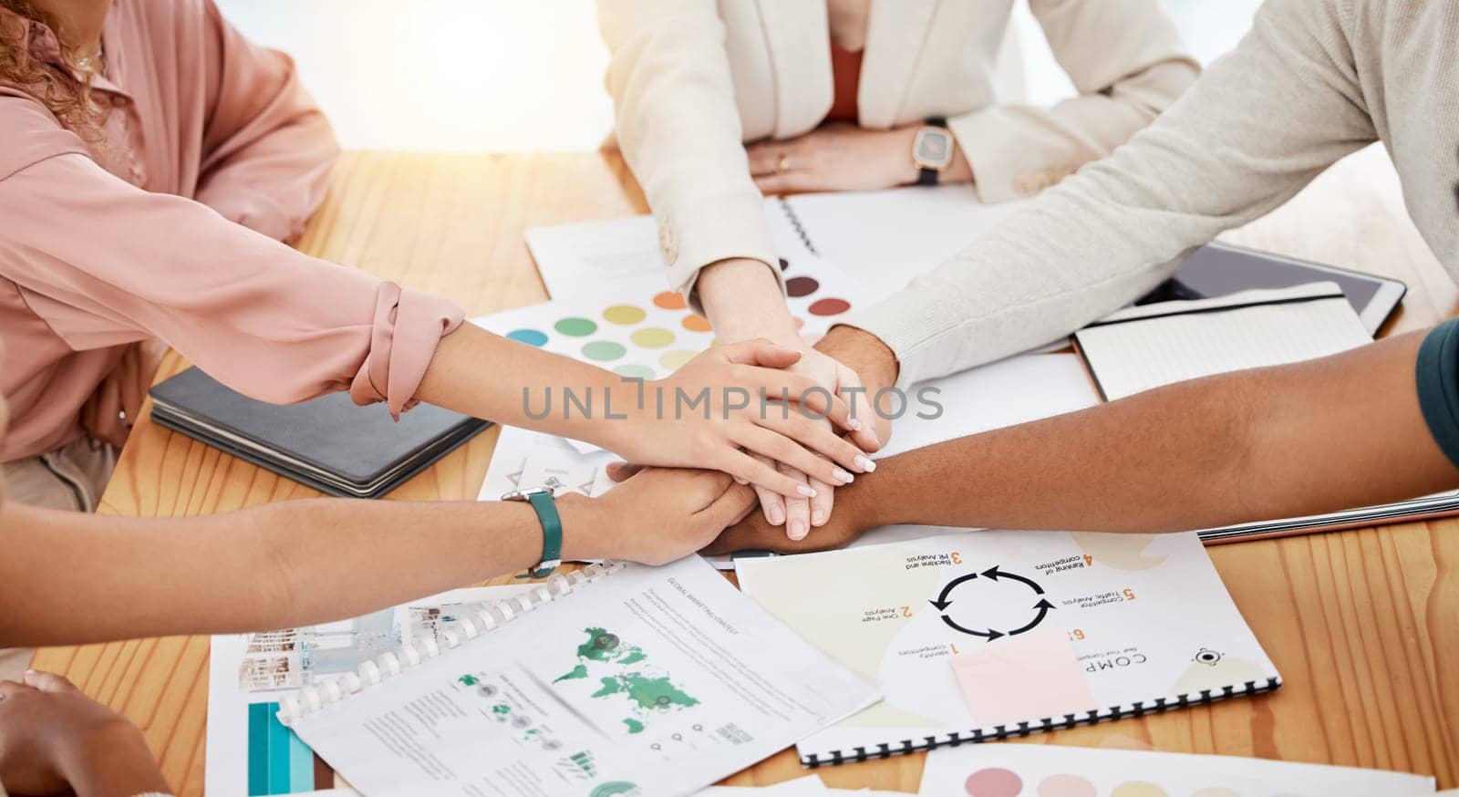 Hands stacked, business and creative people for brand development, project goals and teamwork on documents. Together sign, meeting and graphic designer, marketing agency or person in collaboration.