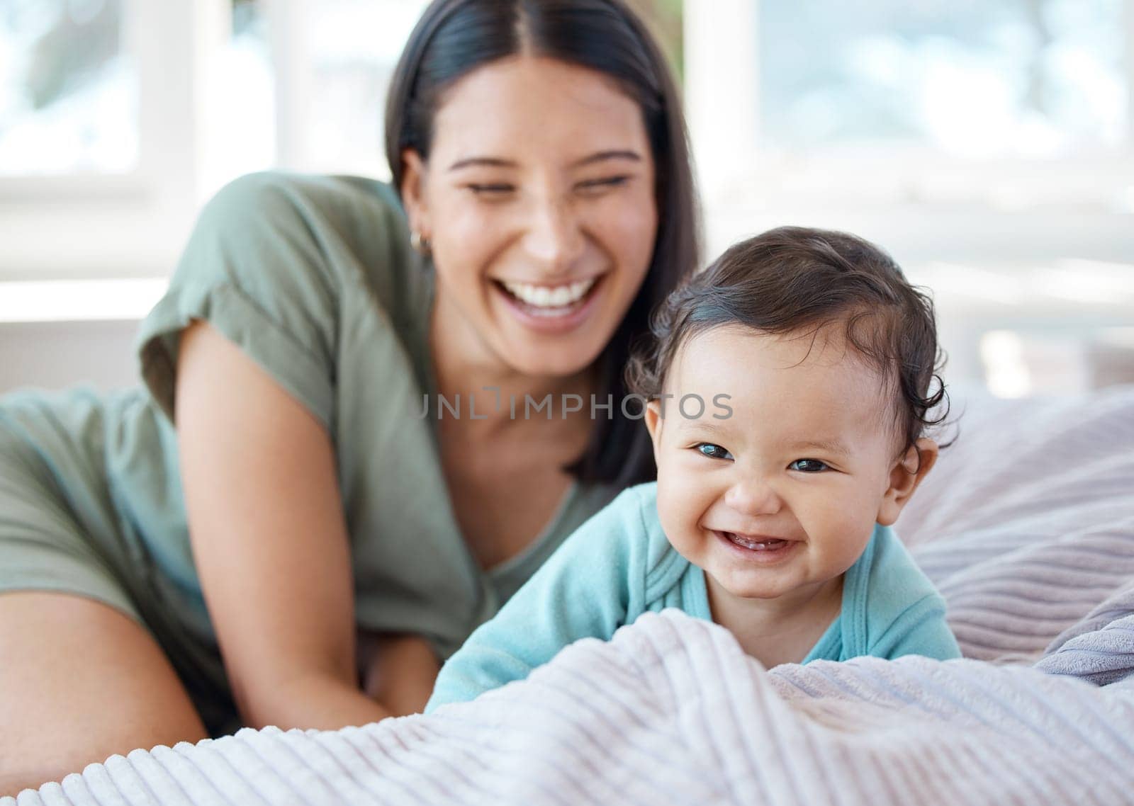 Mother, laughing baby and play on bed in home for love, care and quality time together with joy, growth and kids development. Happy mom, infant child and crawling for fun with newborn girl in bedroom.