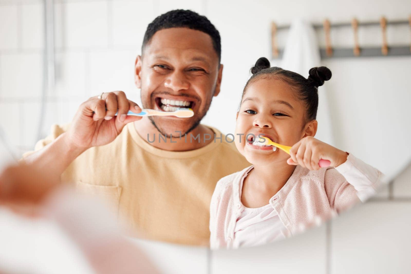 Child, dad and brushing teeth in a family home bathroom for dental health and wellness in a mirror. Face of african man and girl kid learning to clean mouth with toothbrush and smile for oral hygiene by YuriArcurs