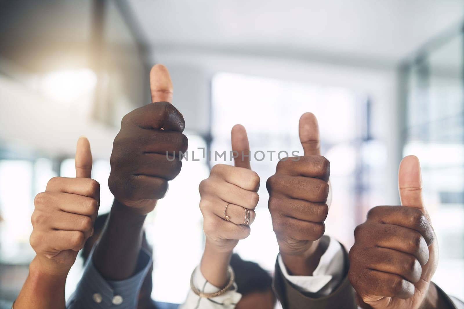 Success will be yours too. Closeup shot of a group of businesspeople showing thumbs up in an office. by YuriArcurs
