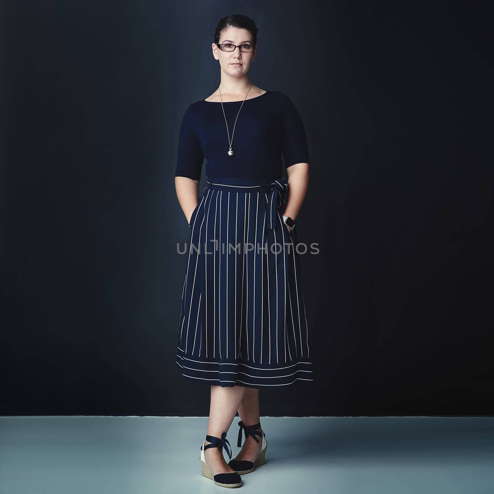 Shes ahead of the game. Studio portrait of a corporate businesswoman posing against a dark background. by YuriArcurs