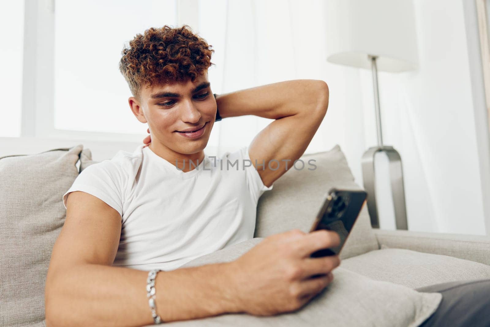 man interior mockup message person mobile online sports student young smile sitting phone internet adult cyberspace text message home smartphone technology