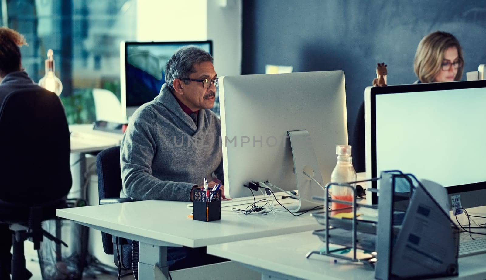 Powering through all their deadlines. a group of businesspeople working late in an office