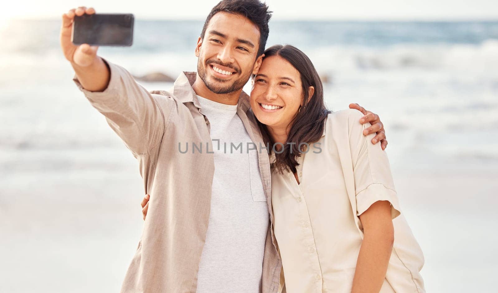 Couple at beach, selfie and travel with happiness outdoor, romantic holiday in Mexico with social media post and love. Trust, care and commitment, man and woman smile in picture with ocean and memory.