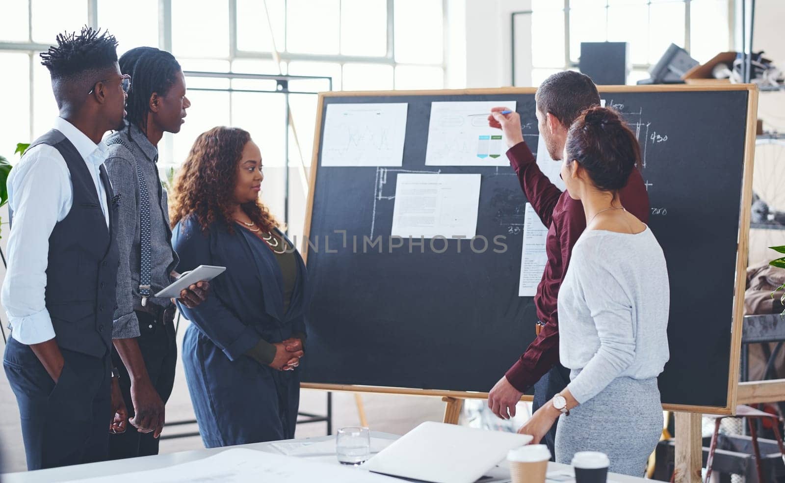 Success is simple when they work together for it. a group of businesspeople brainstorming in an office. by YuriArcurs