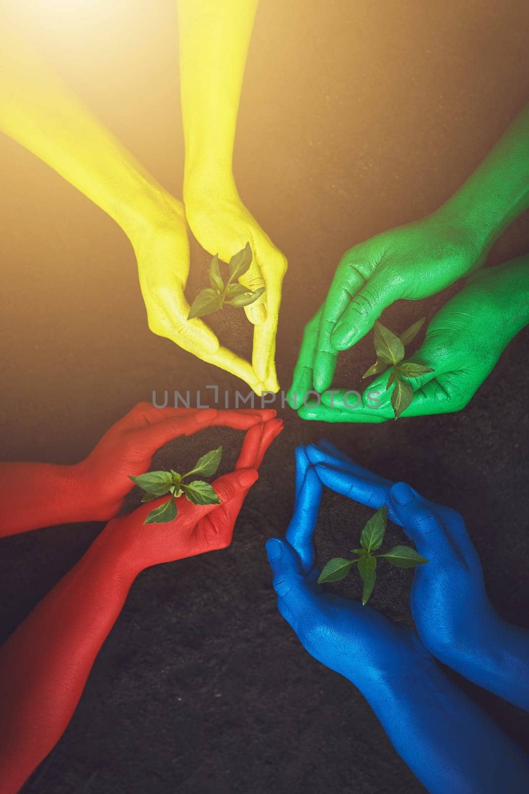 The light of the world and its colors will shine on you. unrecognizable people holding budding plants in their multi colored hands. by YuriArcurs
