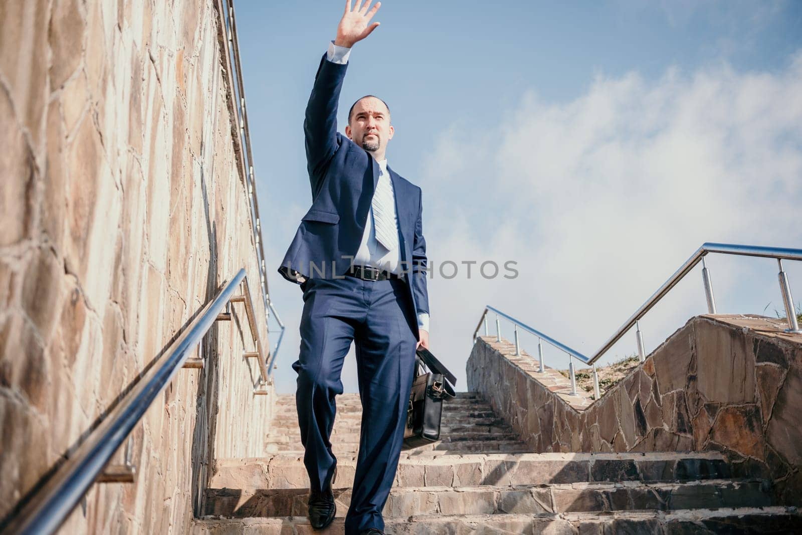 Business executive with briefcase going down the stairs.