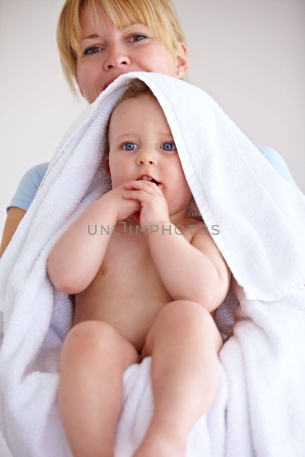 Baby, towel and portrait with care for mother with comfort or love in a closeup or family home. Mom, hug and holding an infant for bath with cleaning or affection at house for hygiene with happy kid. by YuriArcurs