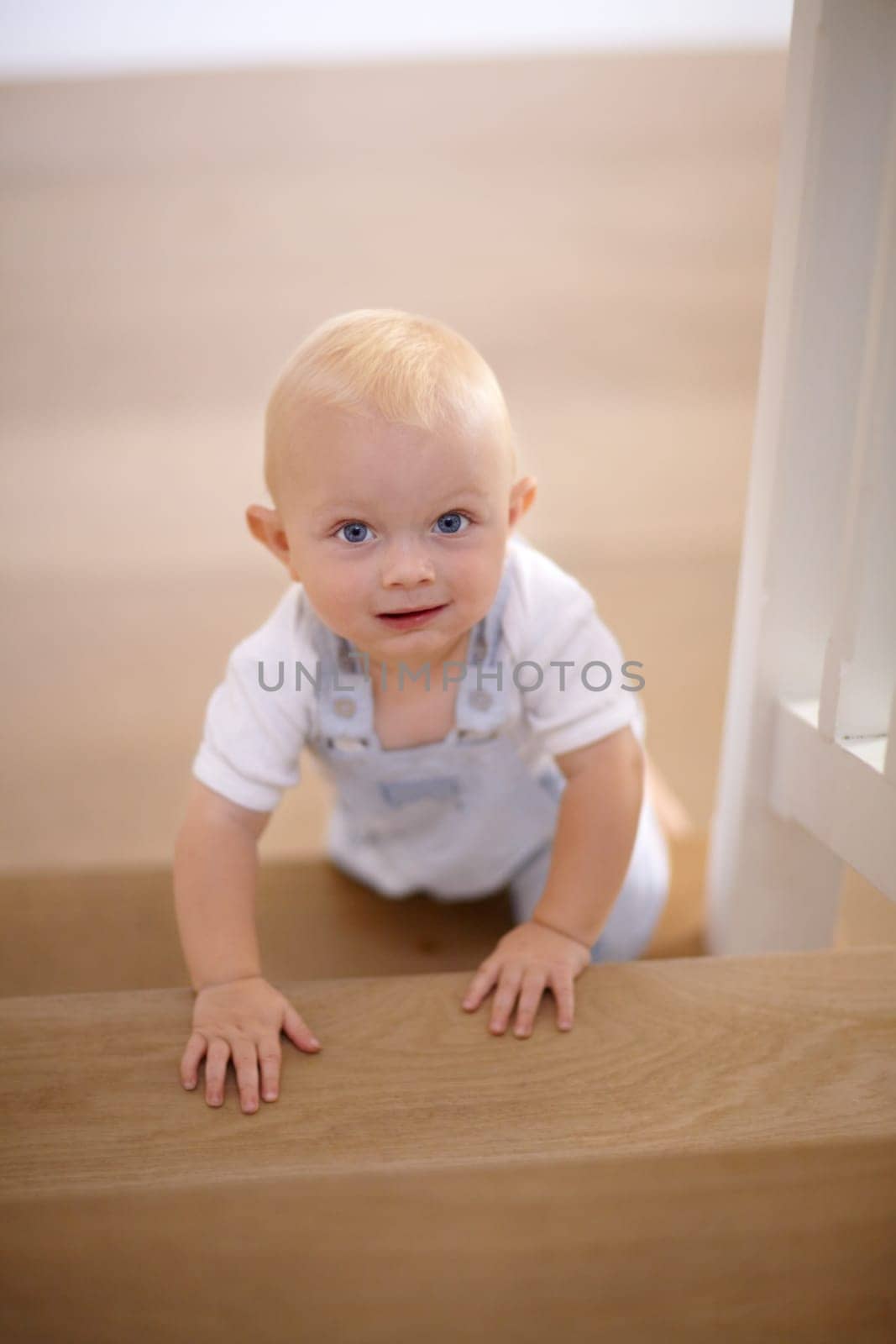 Happy, portrait of baby crawling and at his home with a smile at the stairs. Happiness or childhood development, excited or cheerful and boy child crawl at his house by the staircase smiling by YuriArcurs