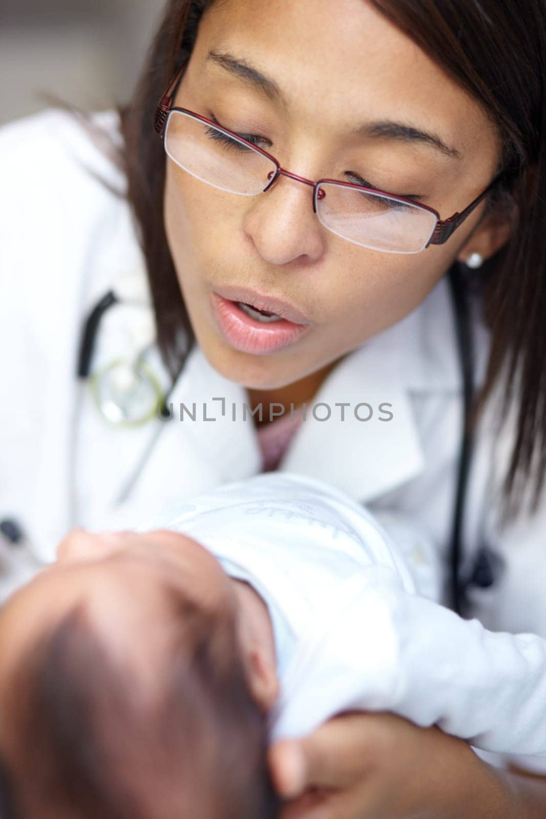 Healthcare, medicine and a pediatrician with a baby in the hospital for insurance, care or treatment. Medical, kids and a doctor woman holding a newborn infant in a health clinic for an appointment by YuriArcurs