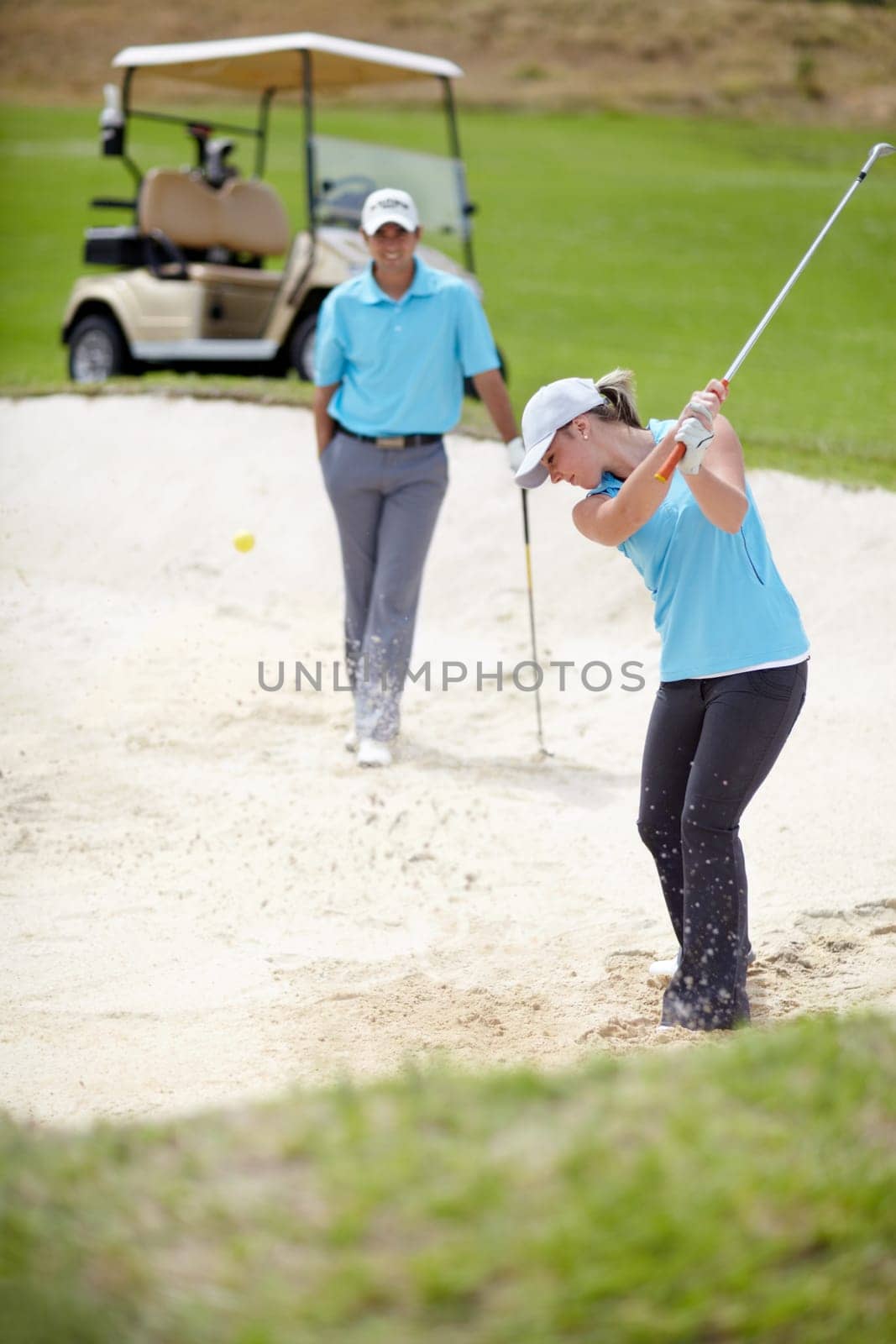 Golf course, sports and woman golfer playing sport for fitness, workout and exercise with a swing on a sand. Wellness, person and athlete training in action or outdoor game with a club stroke by YuriArcurs