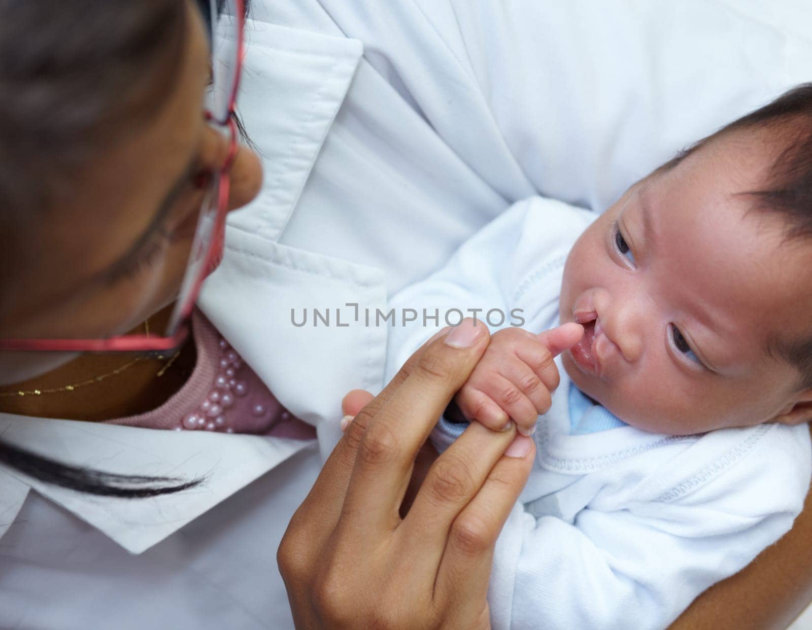 Healthcare, cleft lip and a pediatrician with a baby in the hospital for insurance, care or treatment. Medical, children and a doctor woman holding a newborn with a disability in a health clinic by YuriArcurs