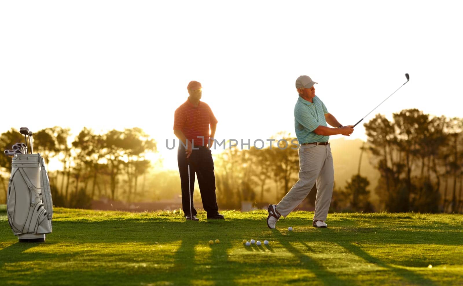 Sunset, golf and men on a course for training, competition or professional game. Fitness, summer and friends on the grass golfing during retirement for holiday, hobby and recreation at a club.