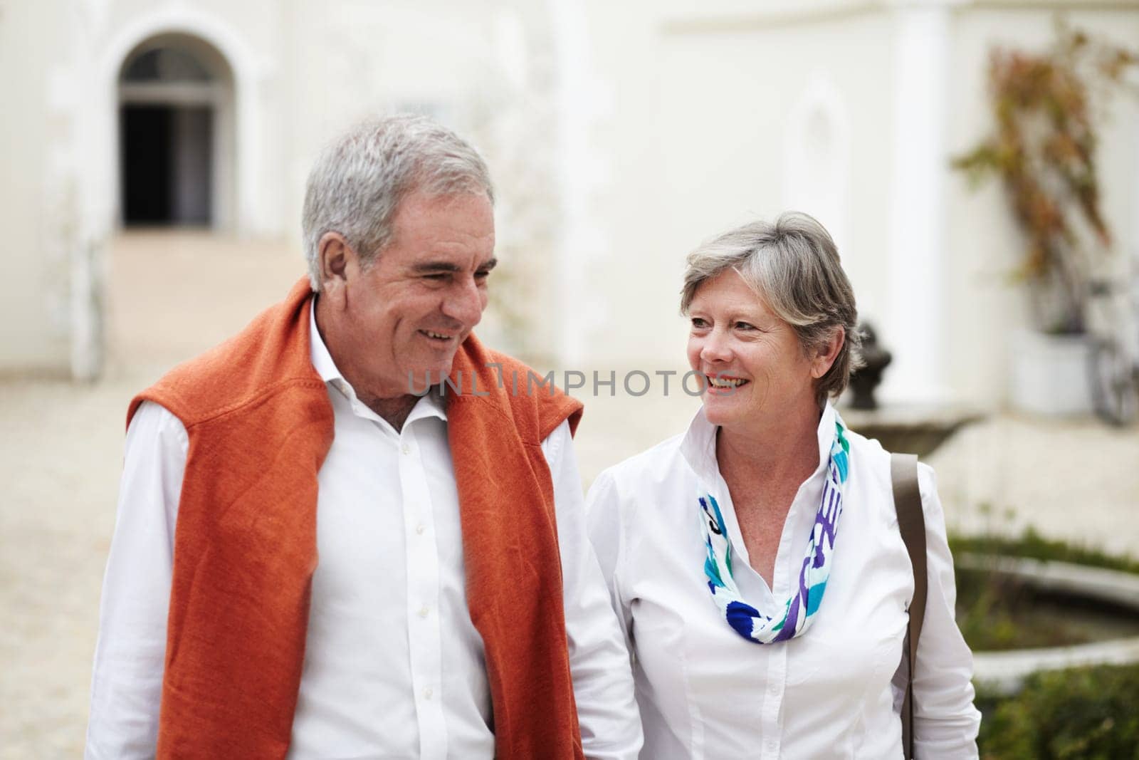 Happy, talking and a senior couple in the city for a retirement holiday, travel and happiness. Smile, love and an elderly man and woman walking in an old town or hotel during a vacation together.