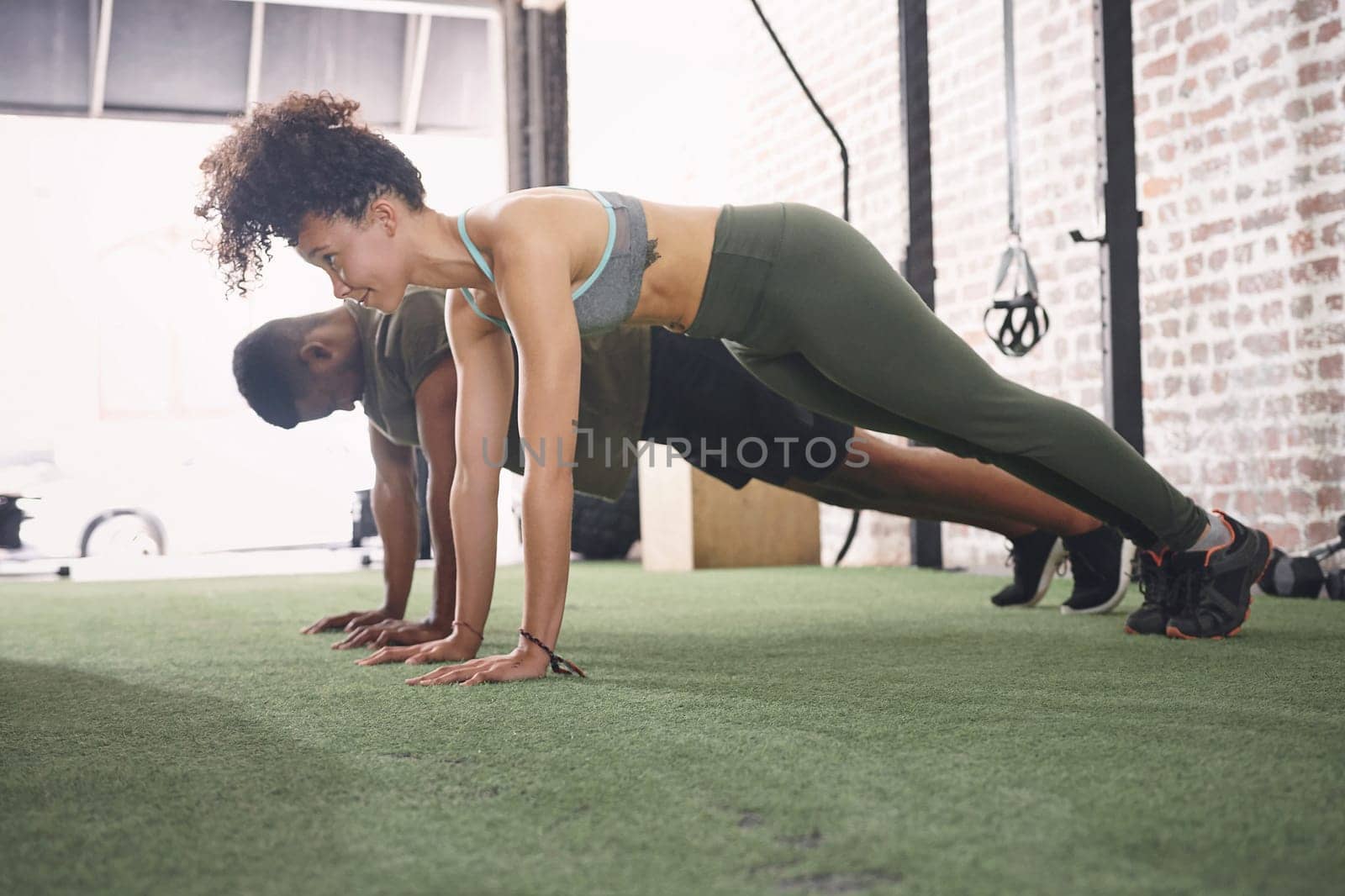 Once you see results, youll always come back for more. two sporty young people doing push-ups together at the gym